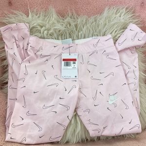 Ankle length soft pink tight fit leggings. Nike swoosh pattern. Large